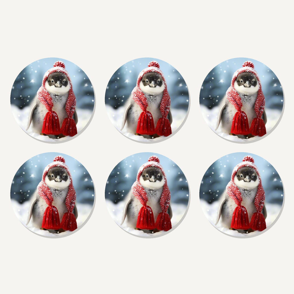 Flat lay of the penguin chick in red knitted hat artwork on six round coasters