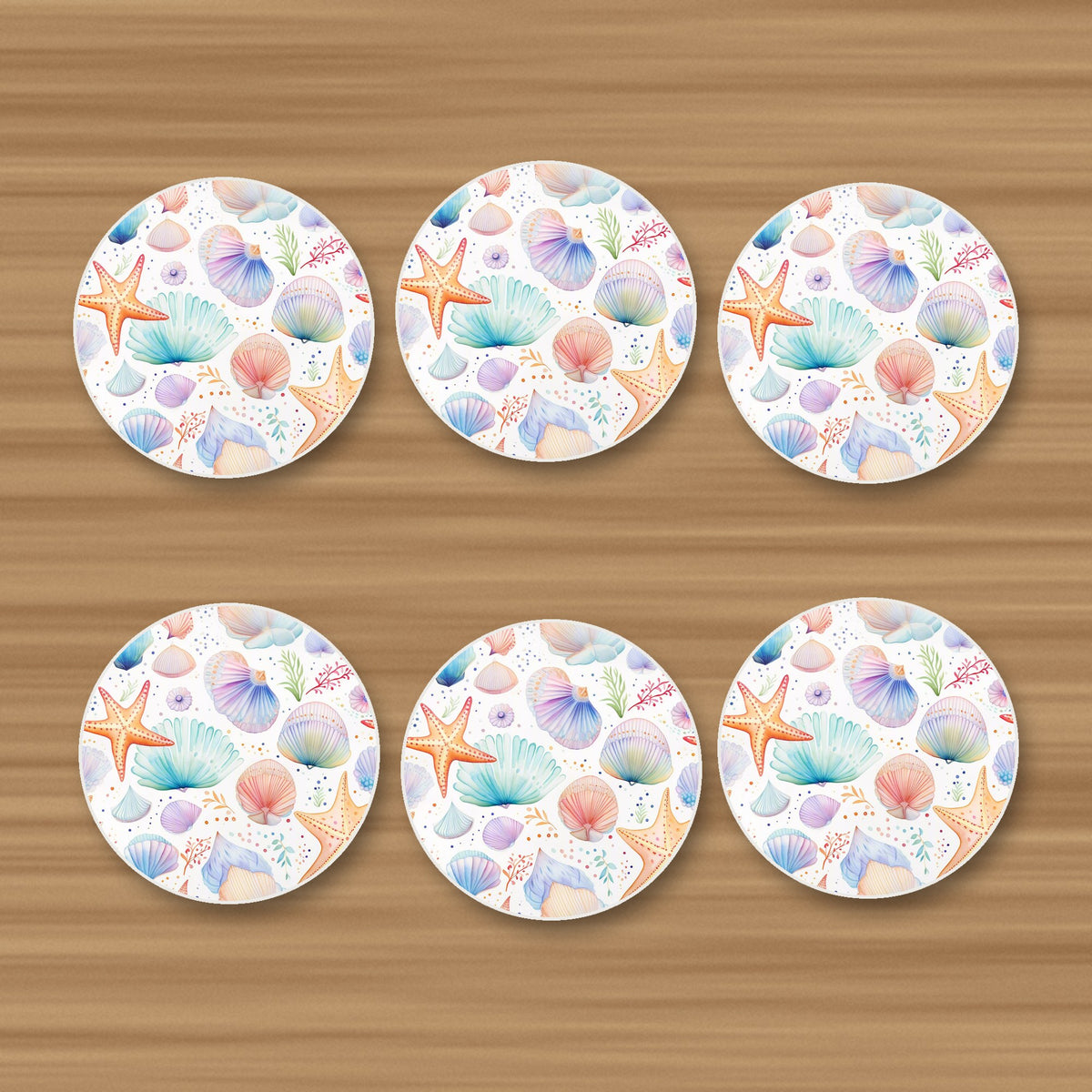 Watercolour Seashells & Starfish round ceramic coasters, set of 6, on an oak coffee table
