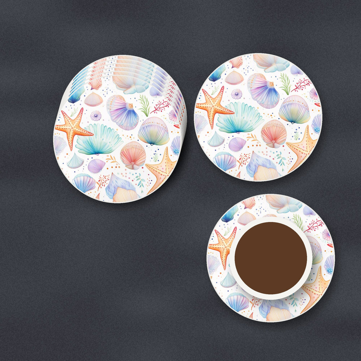 Watercolour Seashells & Starfish round ceramic coasters stacked on a slate kitchen worktop