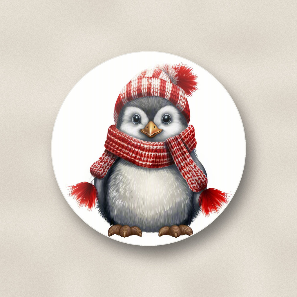 Close-up of one penguin in a red bobble hat round ceramic coaster, flat UV print