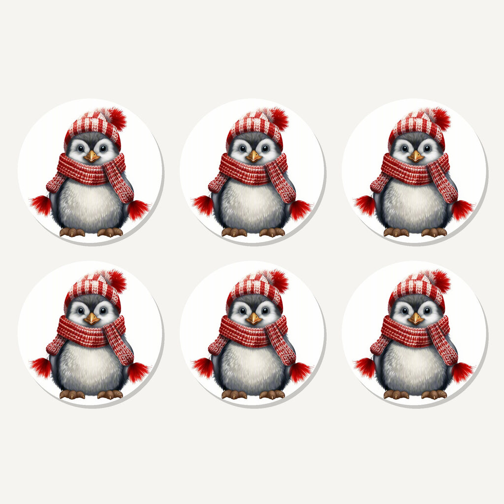 Flat lay of the penguin in a red bobble hat artwork on six round coasters