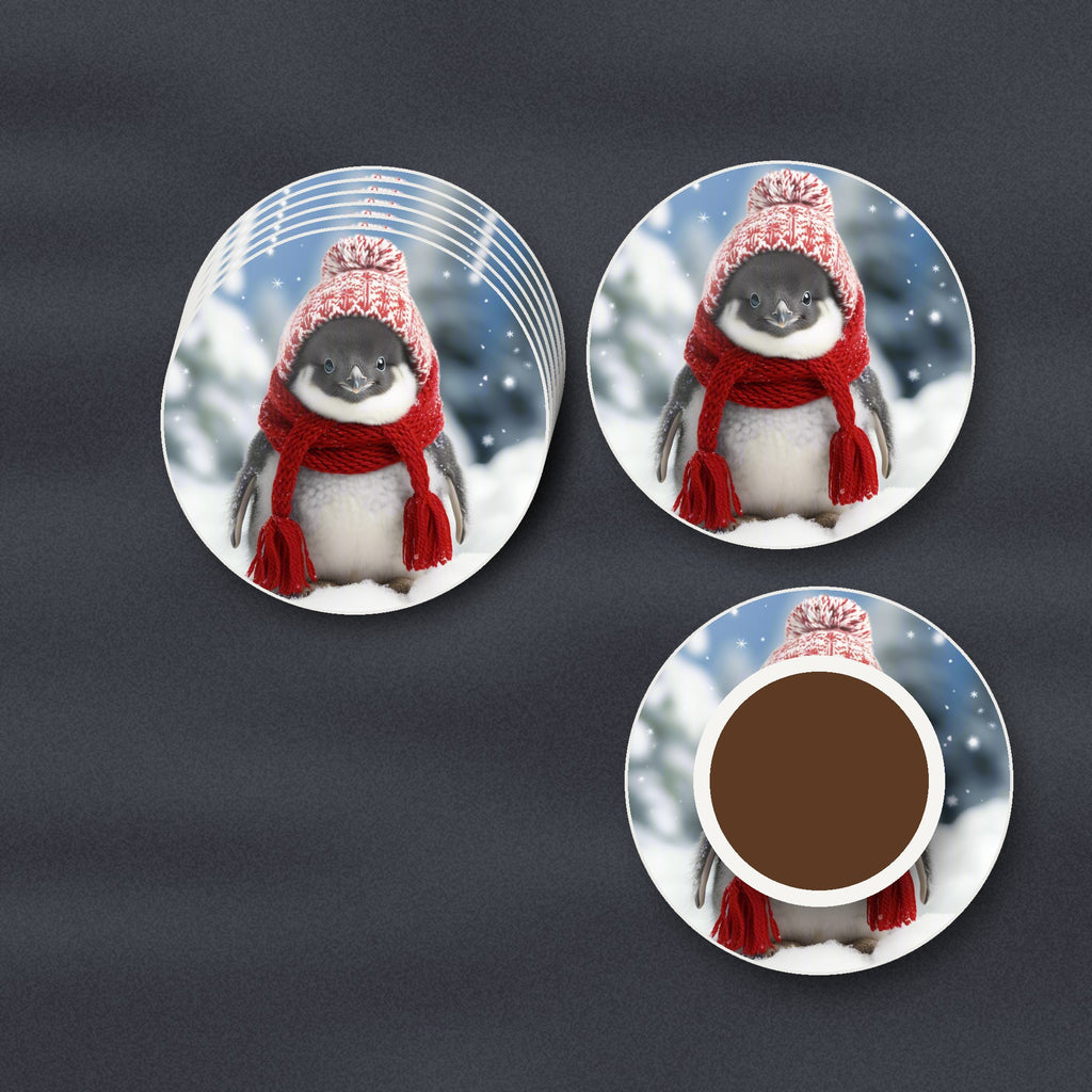 Penguin Chick in the Snow round ceramic coasters stacked on a slate kitchen worktop