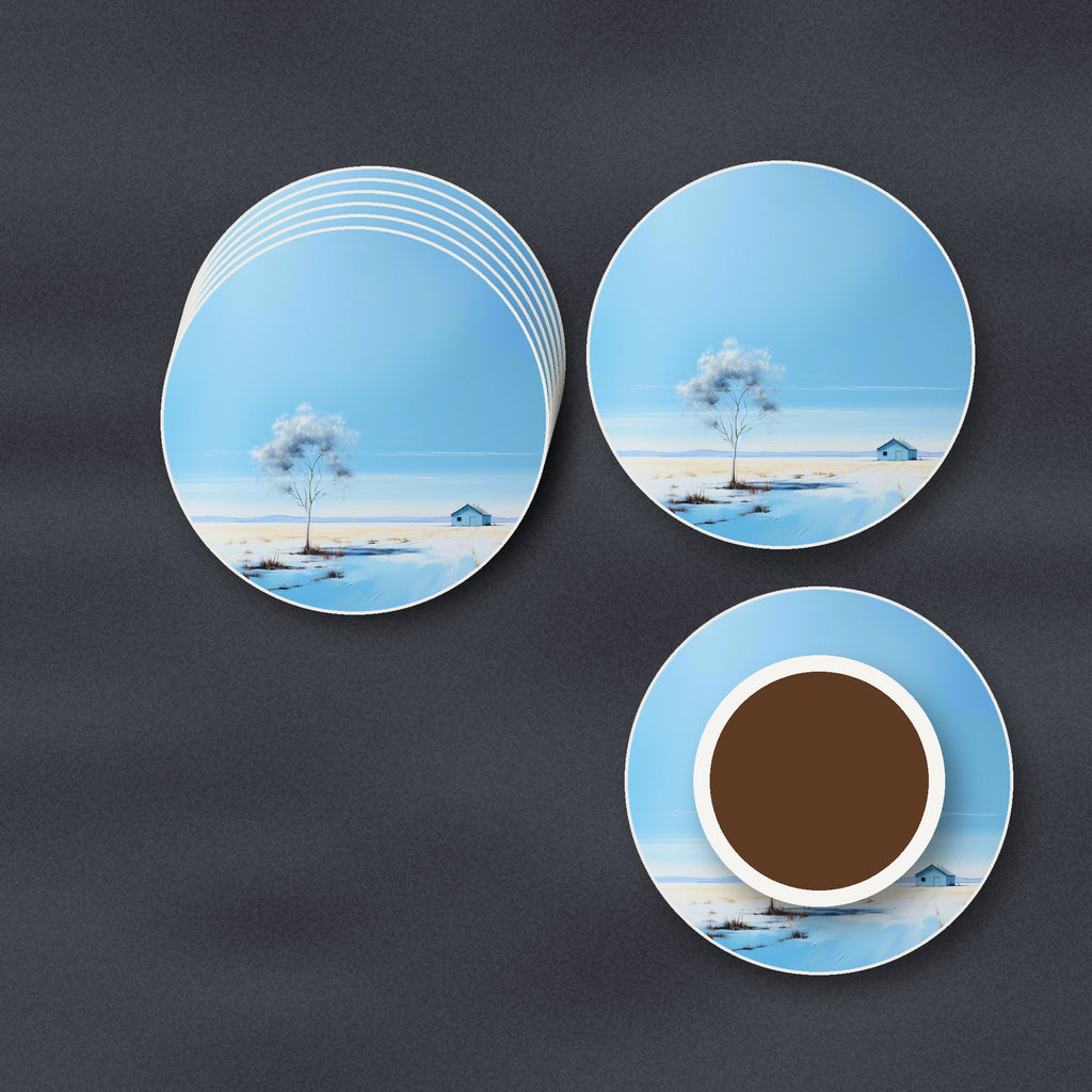 Lone Tree in a Snowy Field round ceramic coasters stacked on a slate kitchen worktop
