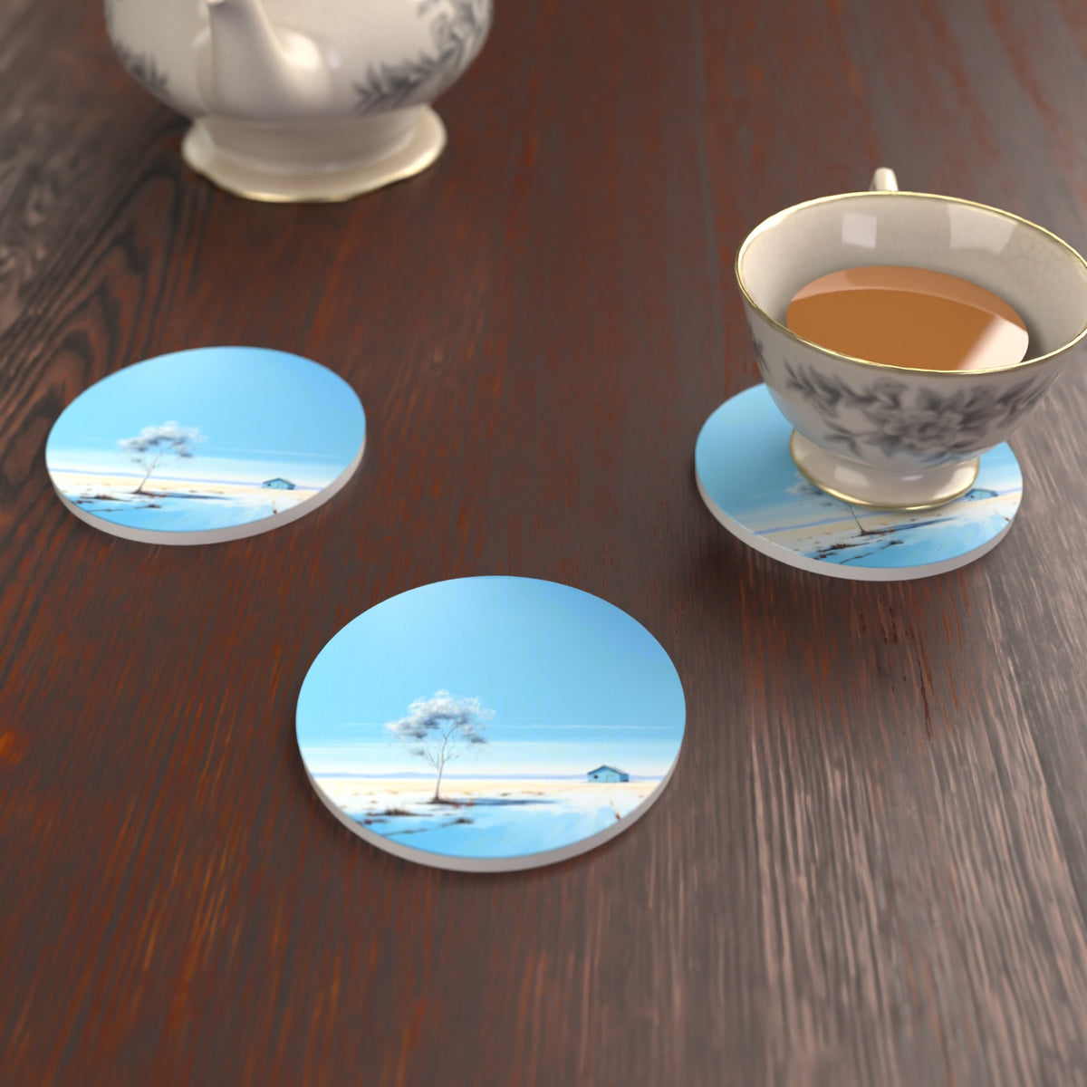 Lone Tree in a Snowy Field Round Ceramic Coasters – Set of 6 – lifestyle mockup with a teacup
