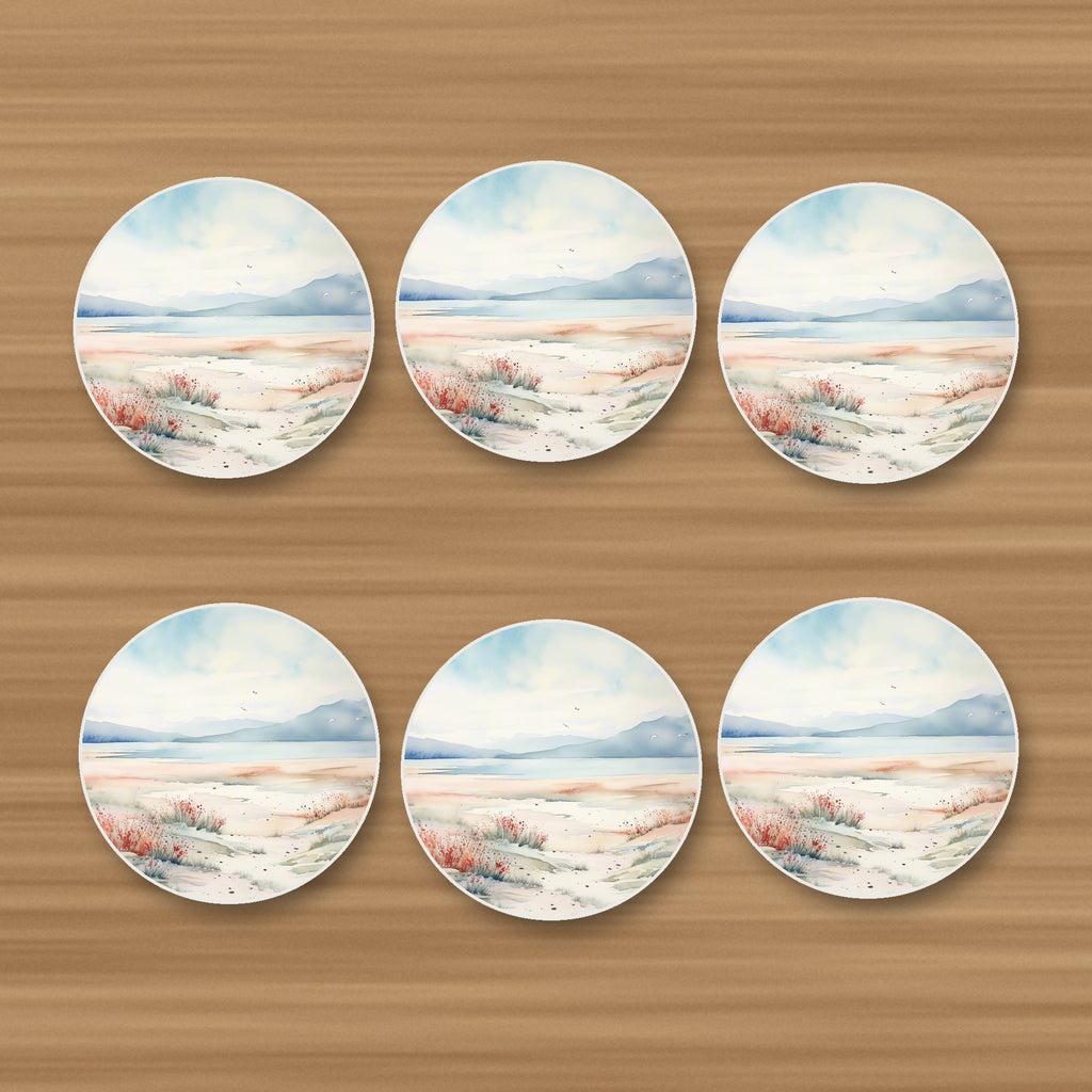 Watercolour Winter Shore round ceramic coasters, set of 6, on an oak coffee table