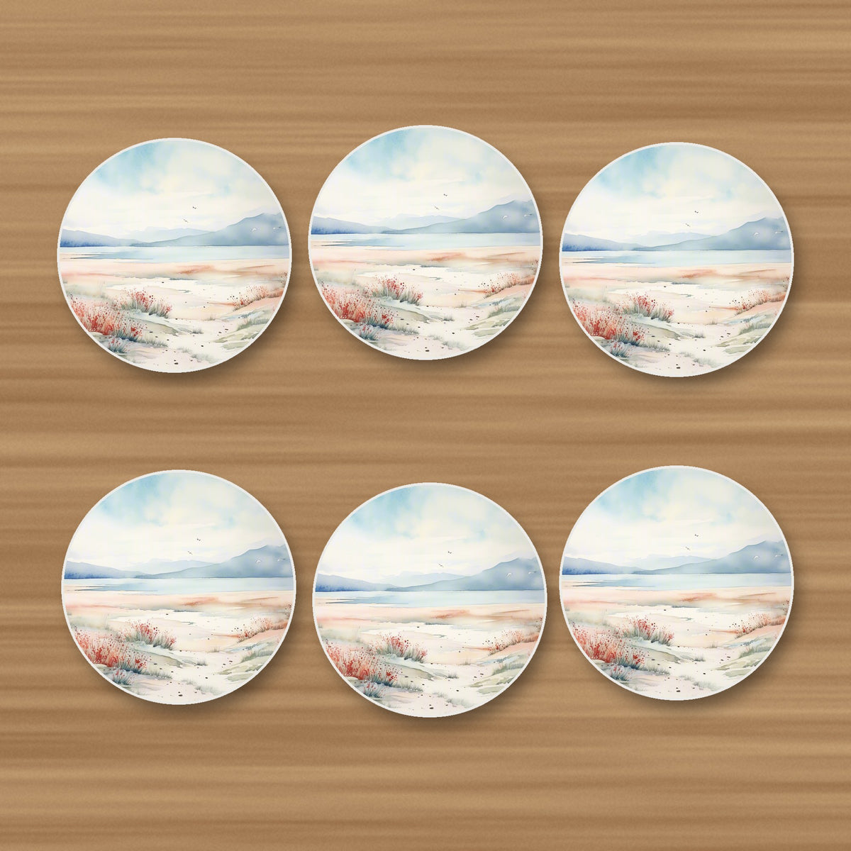 Watercolour Winter Shore round ceramic coasters, set of 6, on an oak coffee table