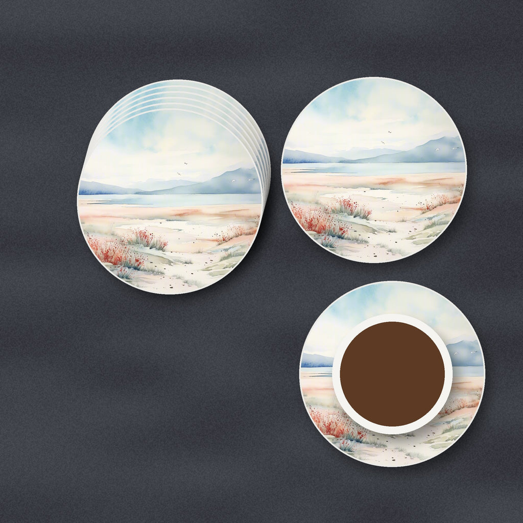 Watercolour Winter Shore round ceramic coasters stacked on a slate kitchen worktop