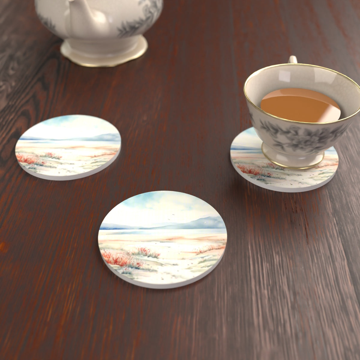 Watercolour Winter Shore Round Ceramic Coasters – Set of 6 – lifestyle mockup with a teacup