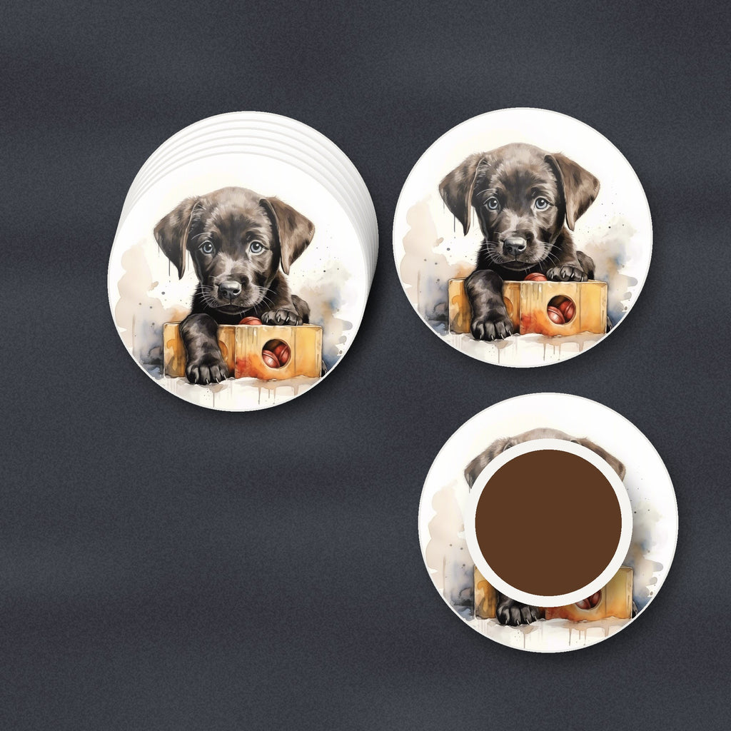 Black Labrador Puppy with Toy Box round ceramic coasters stacked on a slate kitchen worktop