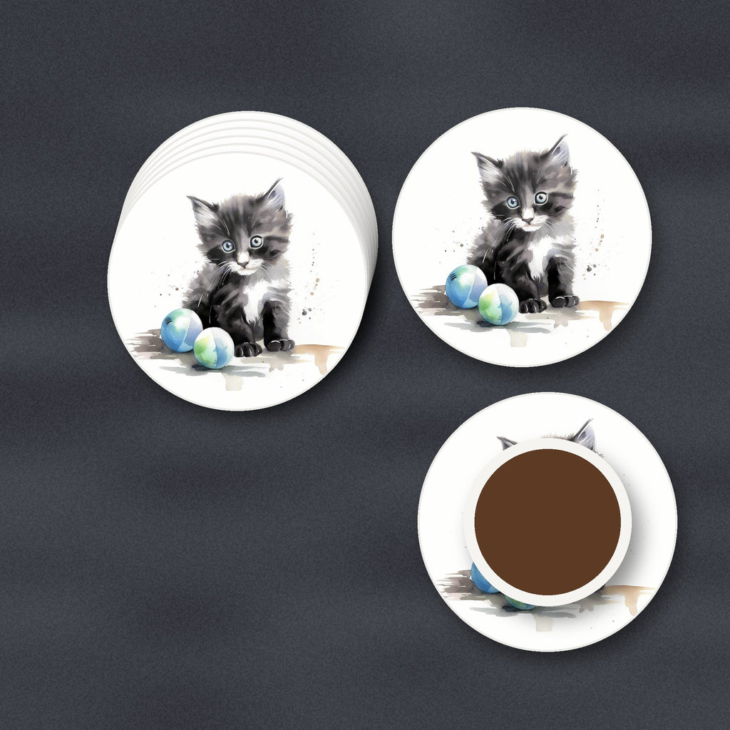 Black & White Kitten with Balls round ceramic coasters stacked on a slate kitchen worktop