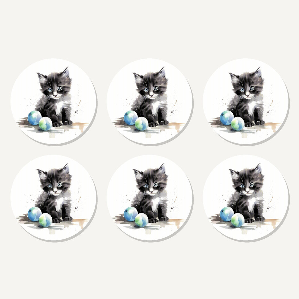 Flat lay of the black & white kitten with balls artwork on six round coasters