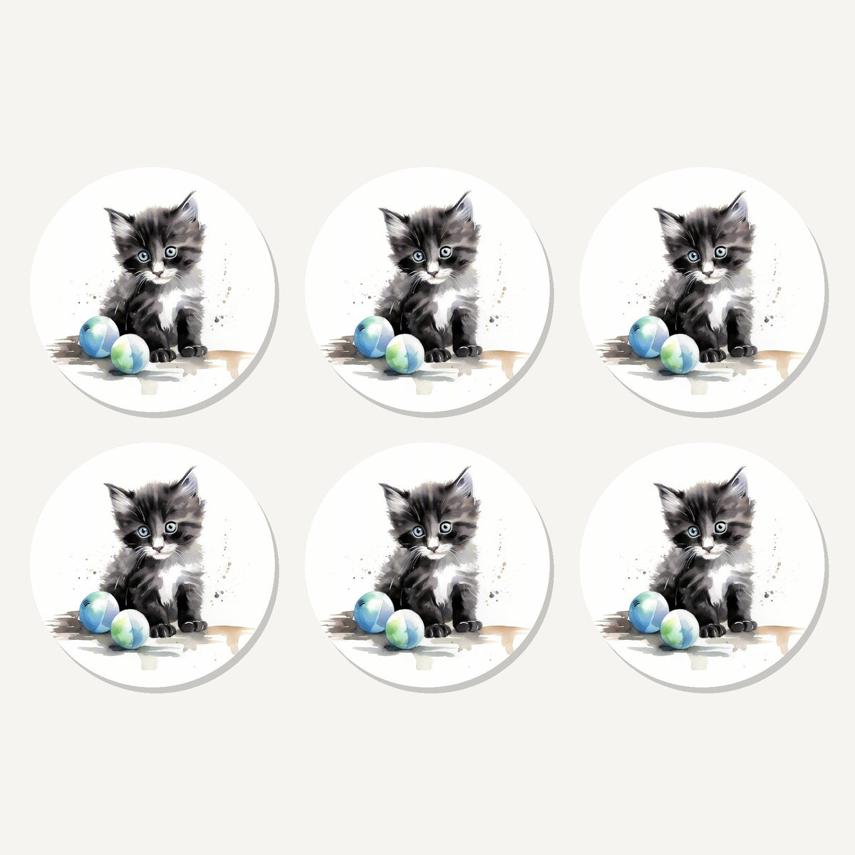 Flat lay of the black & white kitten with balls artwork on six round coasters