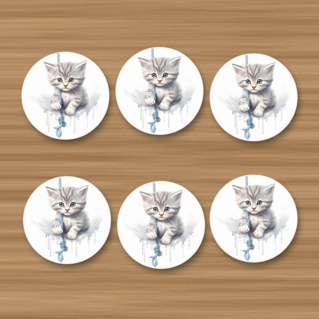 Grey Tabby Kitten on a Rope round ceramic coasters, set of 6, on an oak coffee table