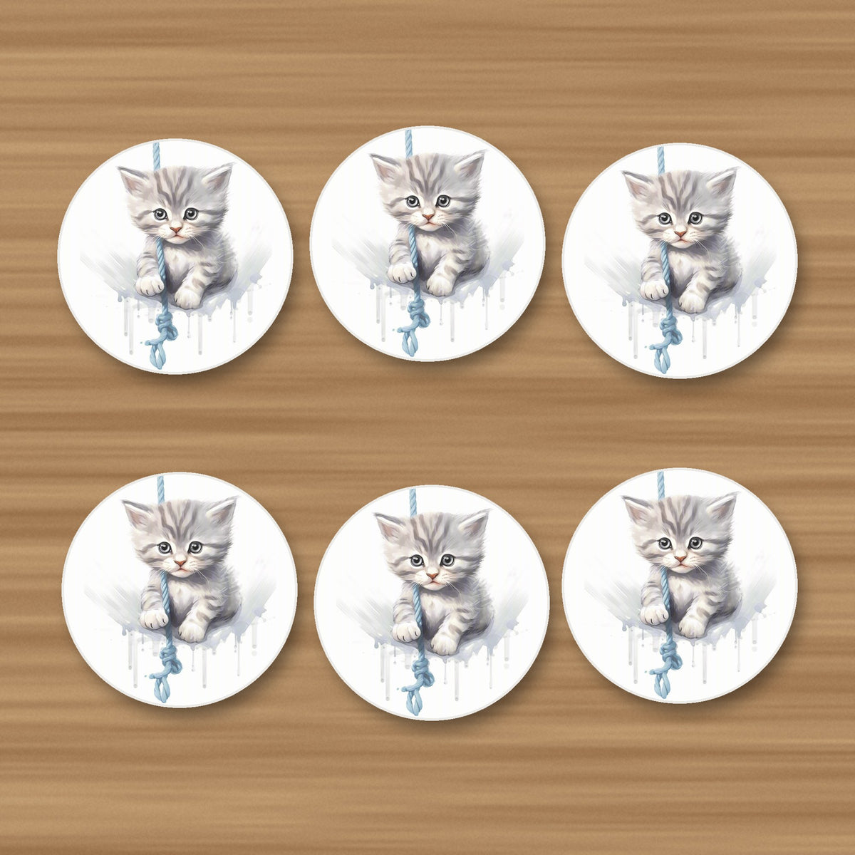 Grey Tabby Kitten on a Rope round ceramic coasters, set of 6, on an oak coffee table