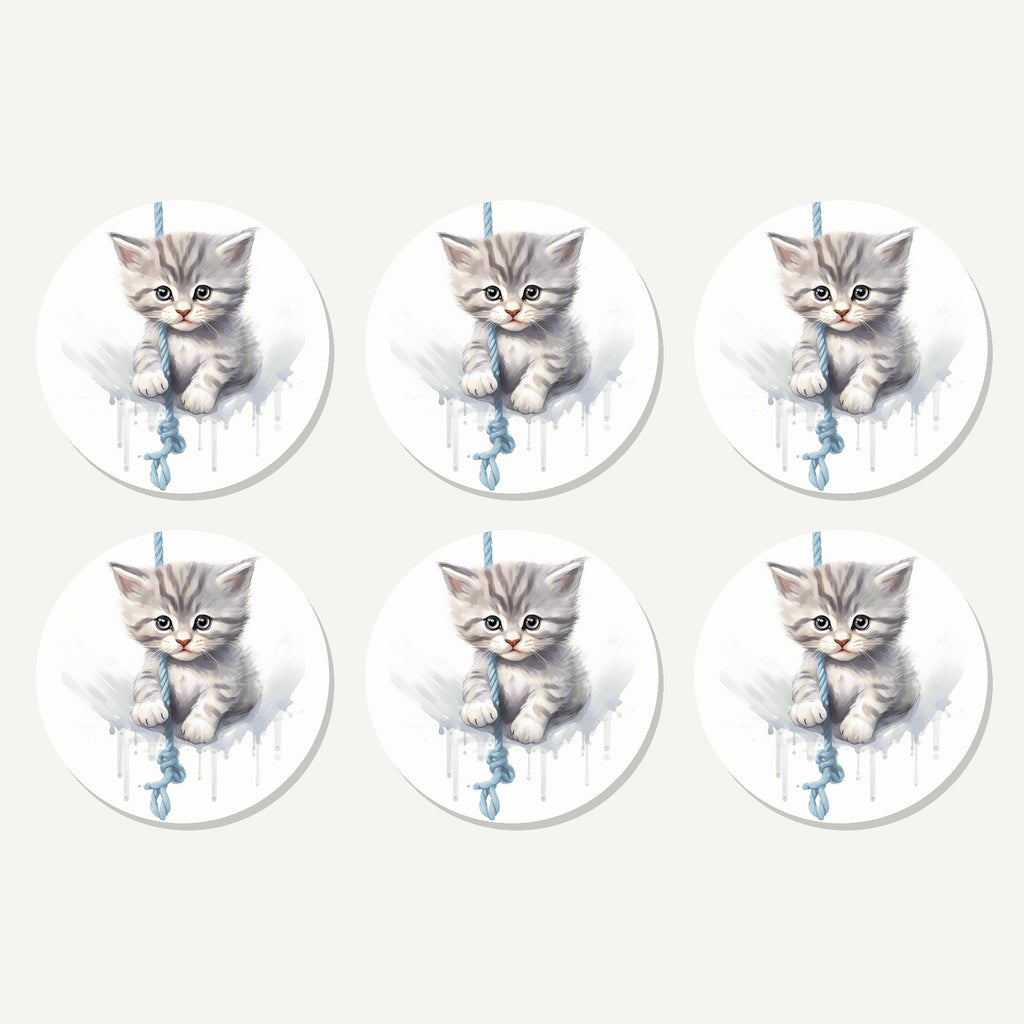 Flat lay of the grey tabby kitten on a rope artwork on six round coasters