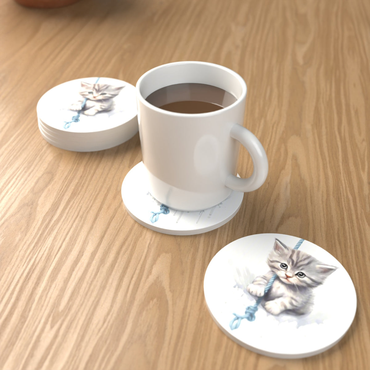 Grey Tabby Kitten on a Rope Round Ceramic Coasters – Set of 6 – lifestyle mockup with a mug of coffee