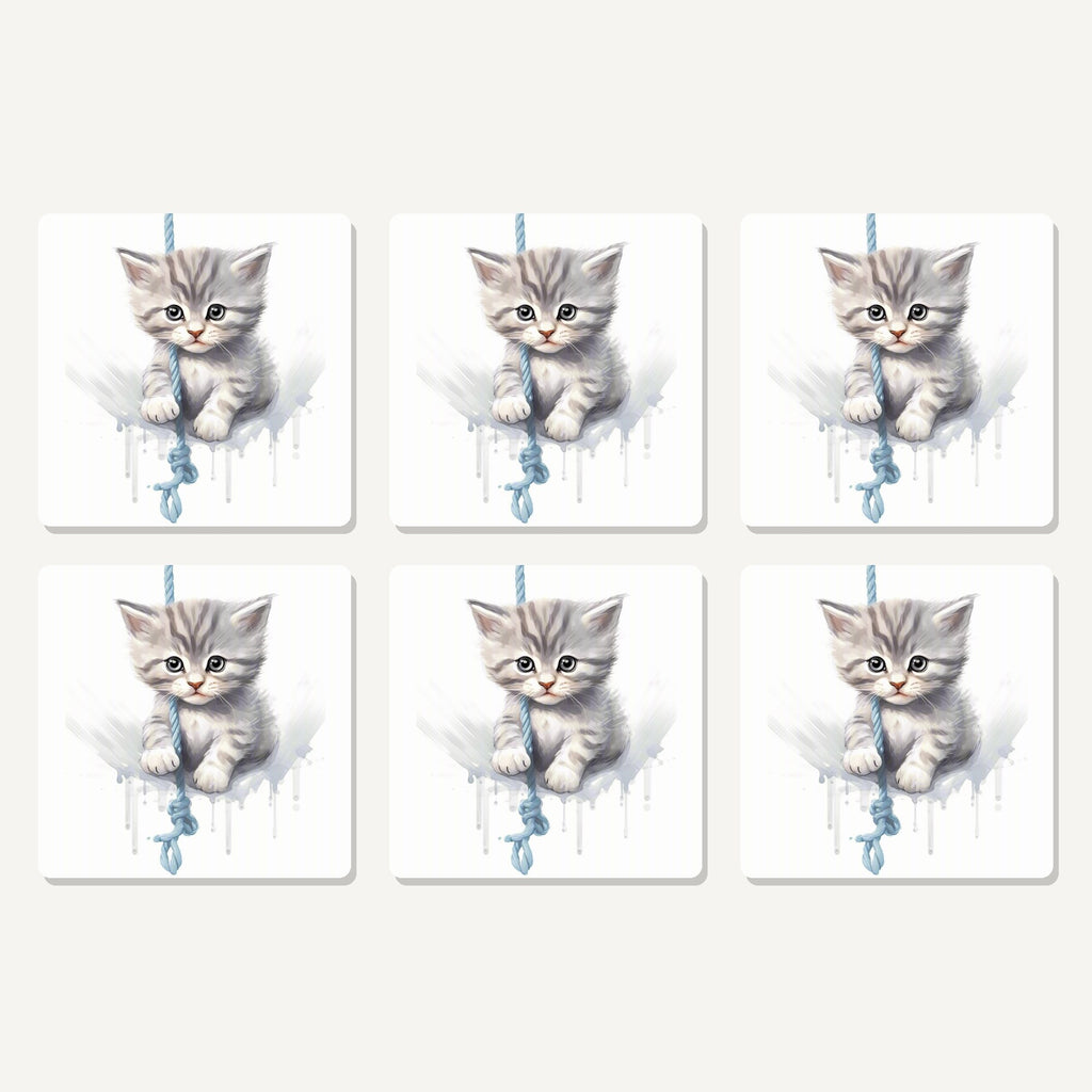 Flat lay of the grey tabby kitten on a rope artwork on six square coasters