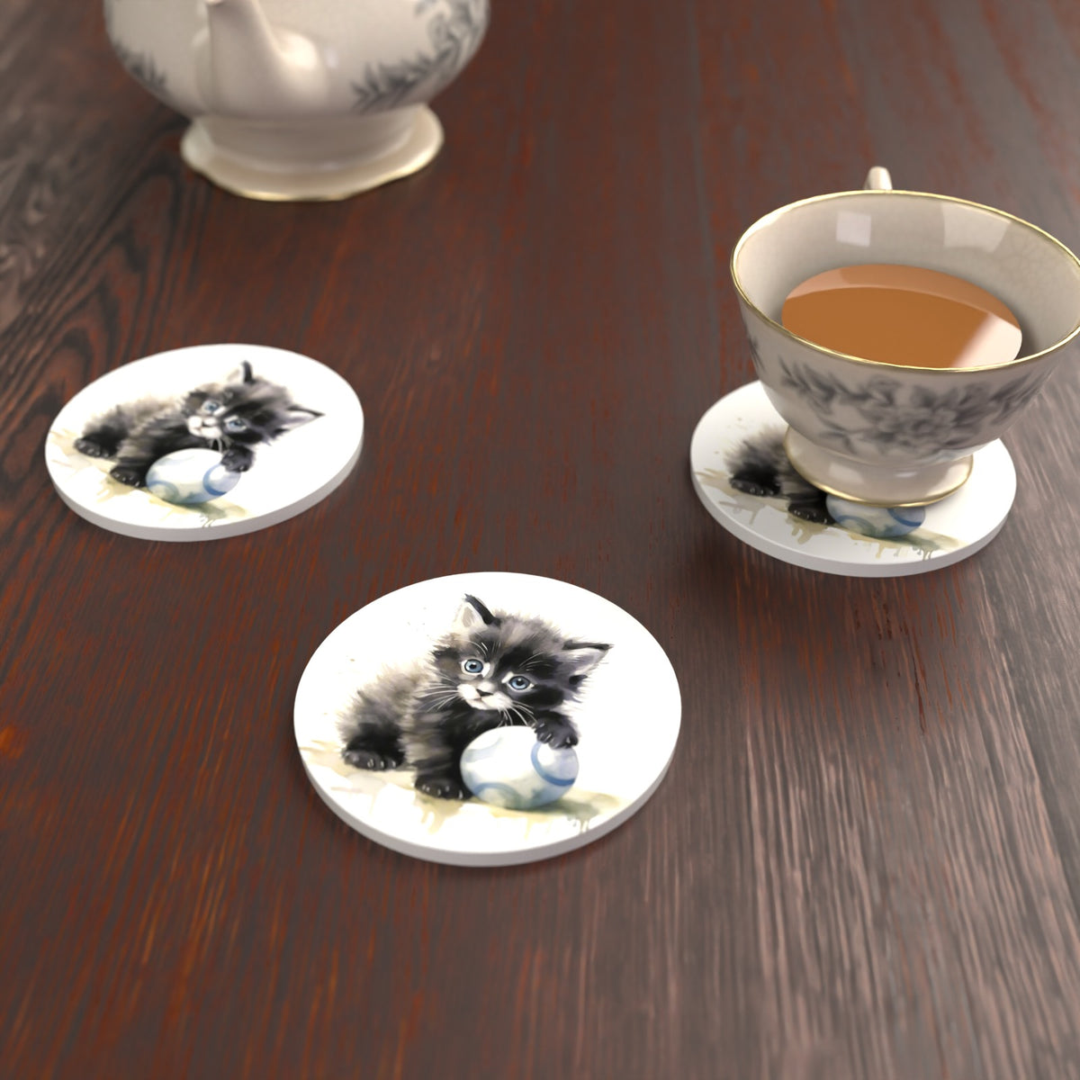 Black Kitten with a Ball Round Ceramic Coasters – Set of 6 – lifestyle mockup with a teacup