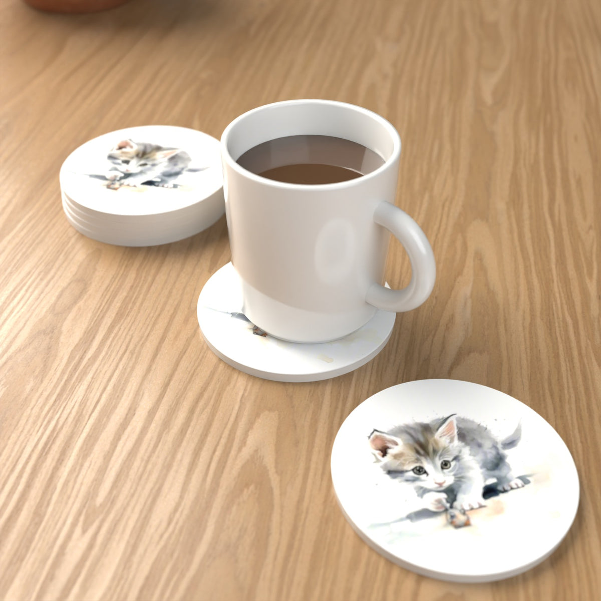 Grey Kitten at Play Round Ceramic Coasters – Set of 6 – lifestyle mockup with a mug of coffee