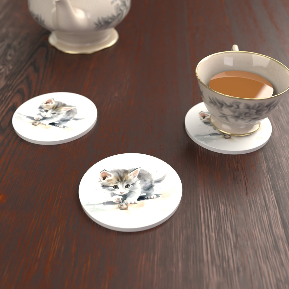 Grey Kitten at Play Round Ceramic Coasters – Set of 6 – lifestyle mockup with a teacup