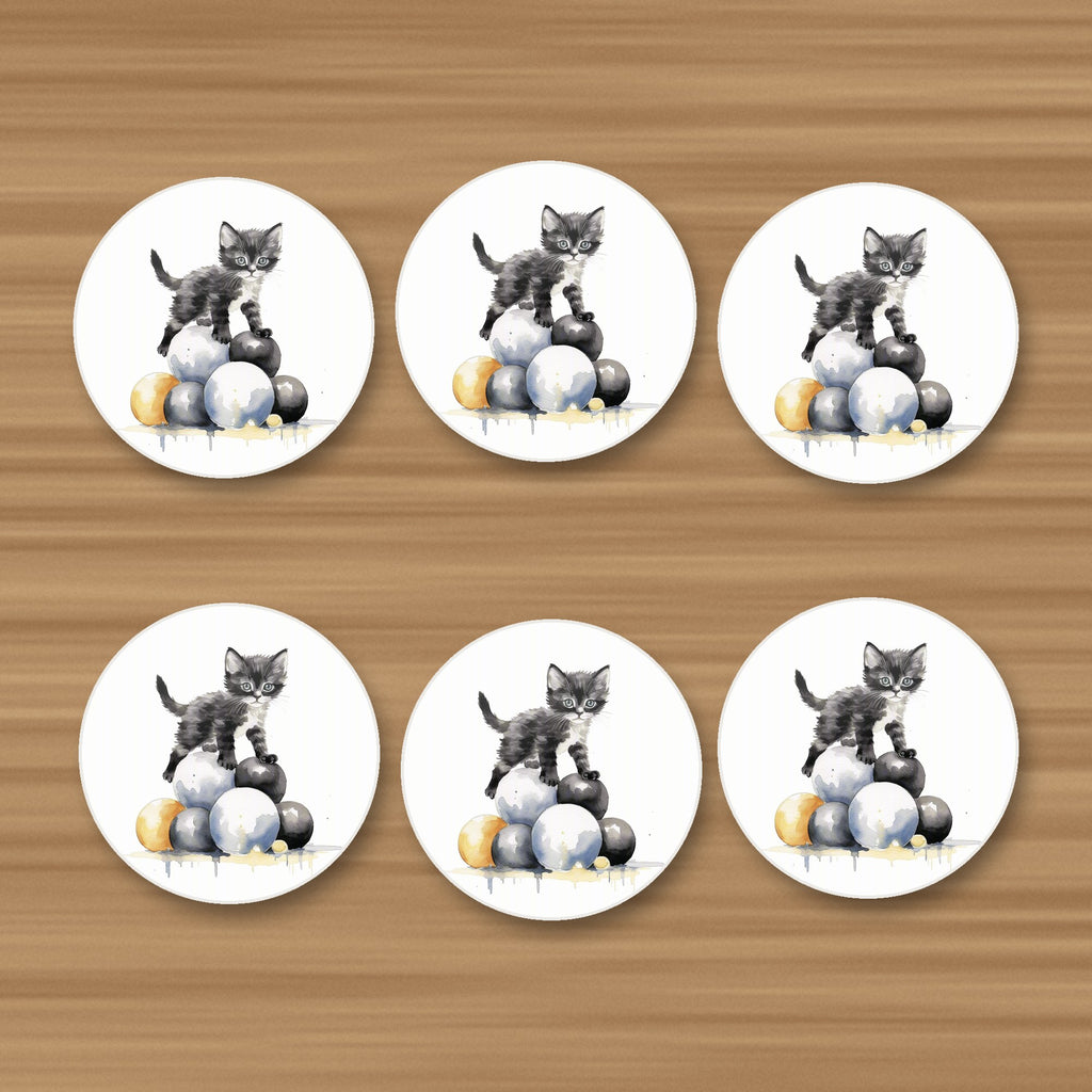 Black Kitten on a Pile of Balls round ceramic coasters, set of 6, on an oak coffee table