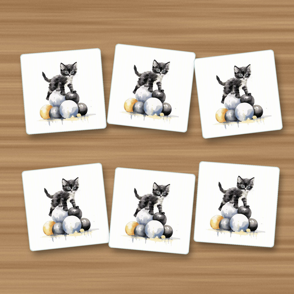 Black Kitten on a Pile of Balls square glass coasters, set of 6, on an oak coffee table