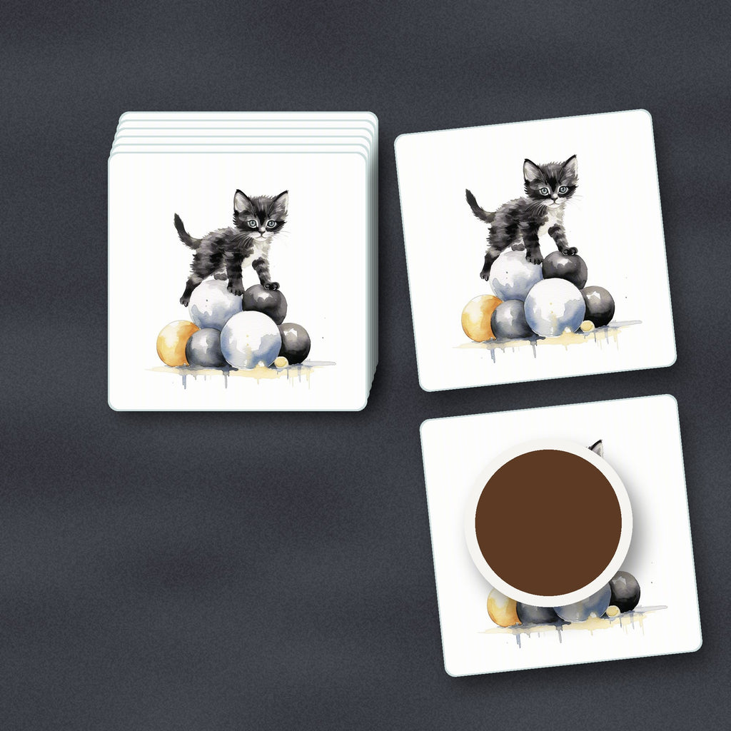 Black Kitten on a Pile of Balls square glass coasters stacked on a slate kitchen worktop