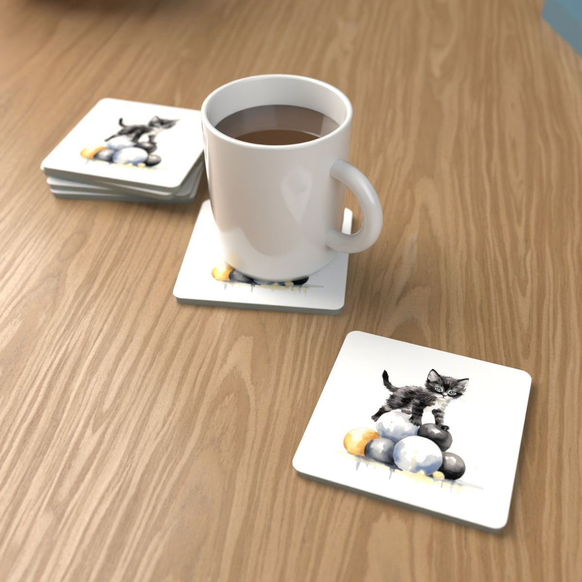 Black Kitten on a Pile of Balls Square Glass Coasters – Set of 6 – lifestyle mockup with a mug of coffee