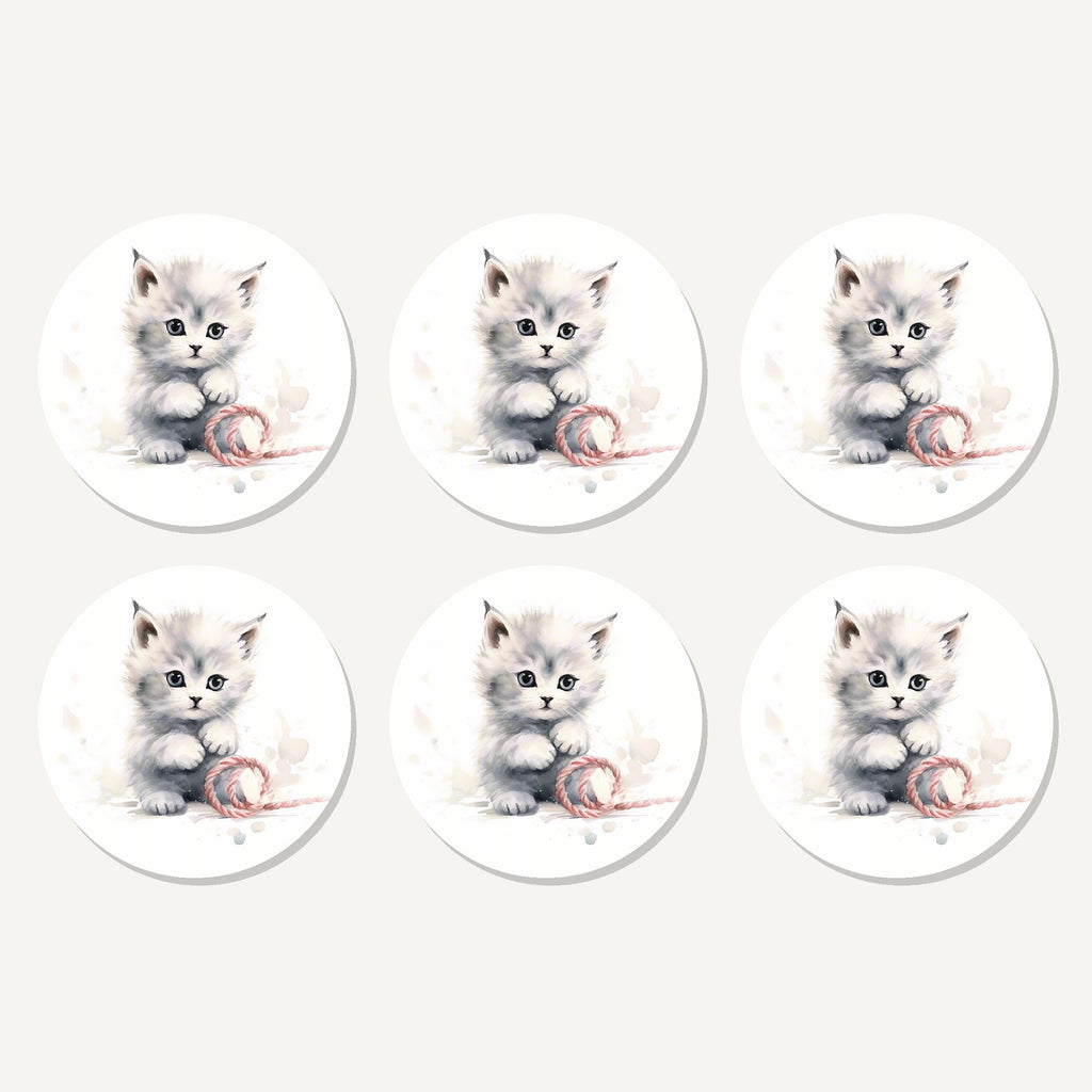 Flat lay of the white kitten with yarn artwork on six round coasters