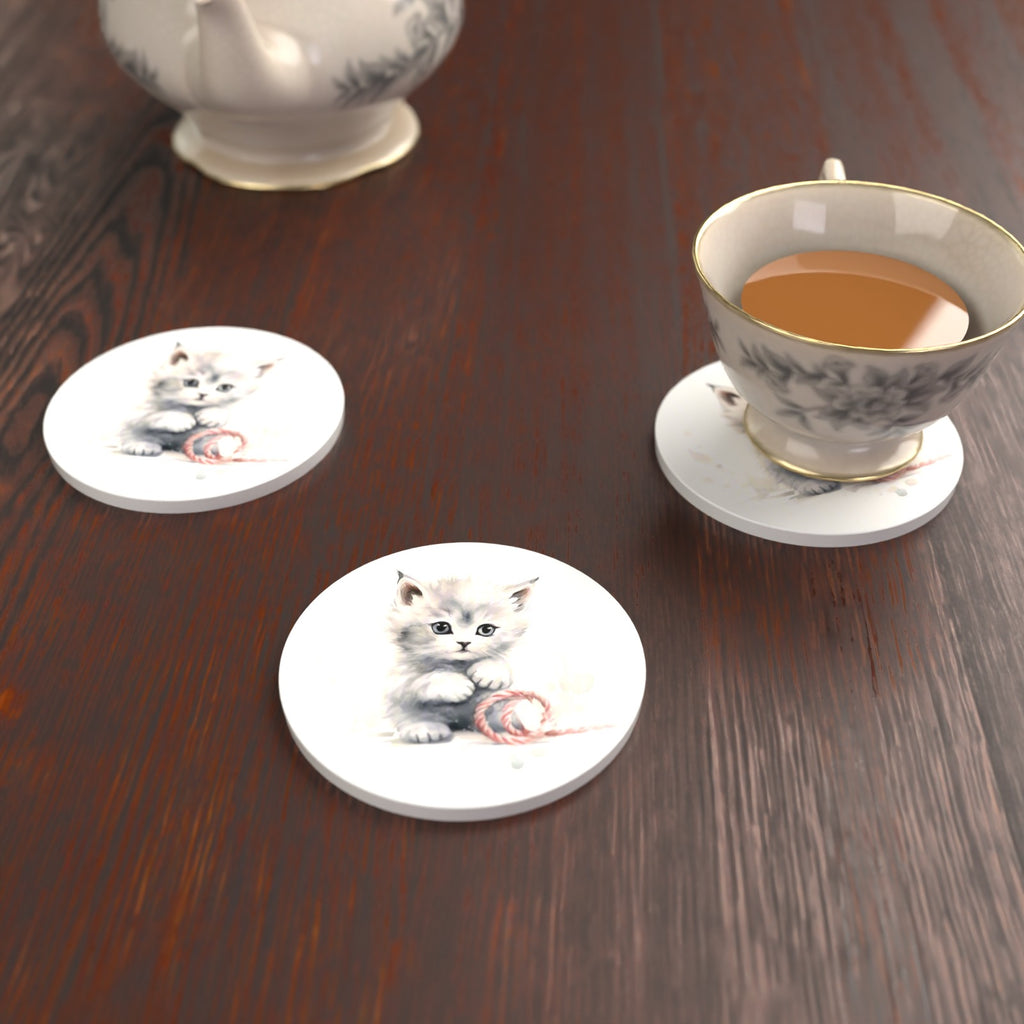White Kitten with Yarn Round Ceramic Coasters – Set of 6 – lifestyle mockup with a teacup