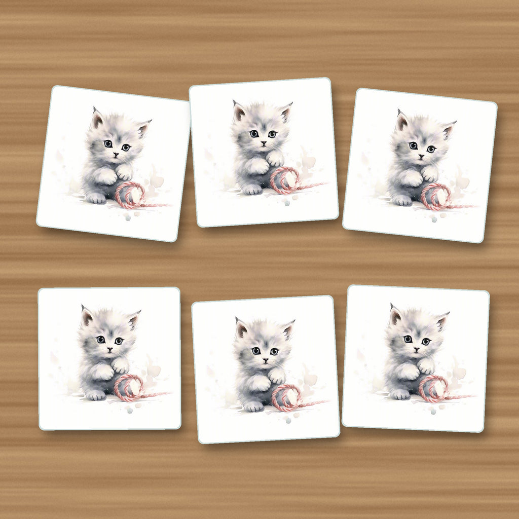 White Kitten with Yarn square glass coasters, set of 6, on an oak coffee table