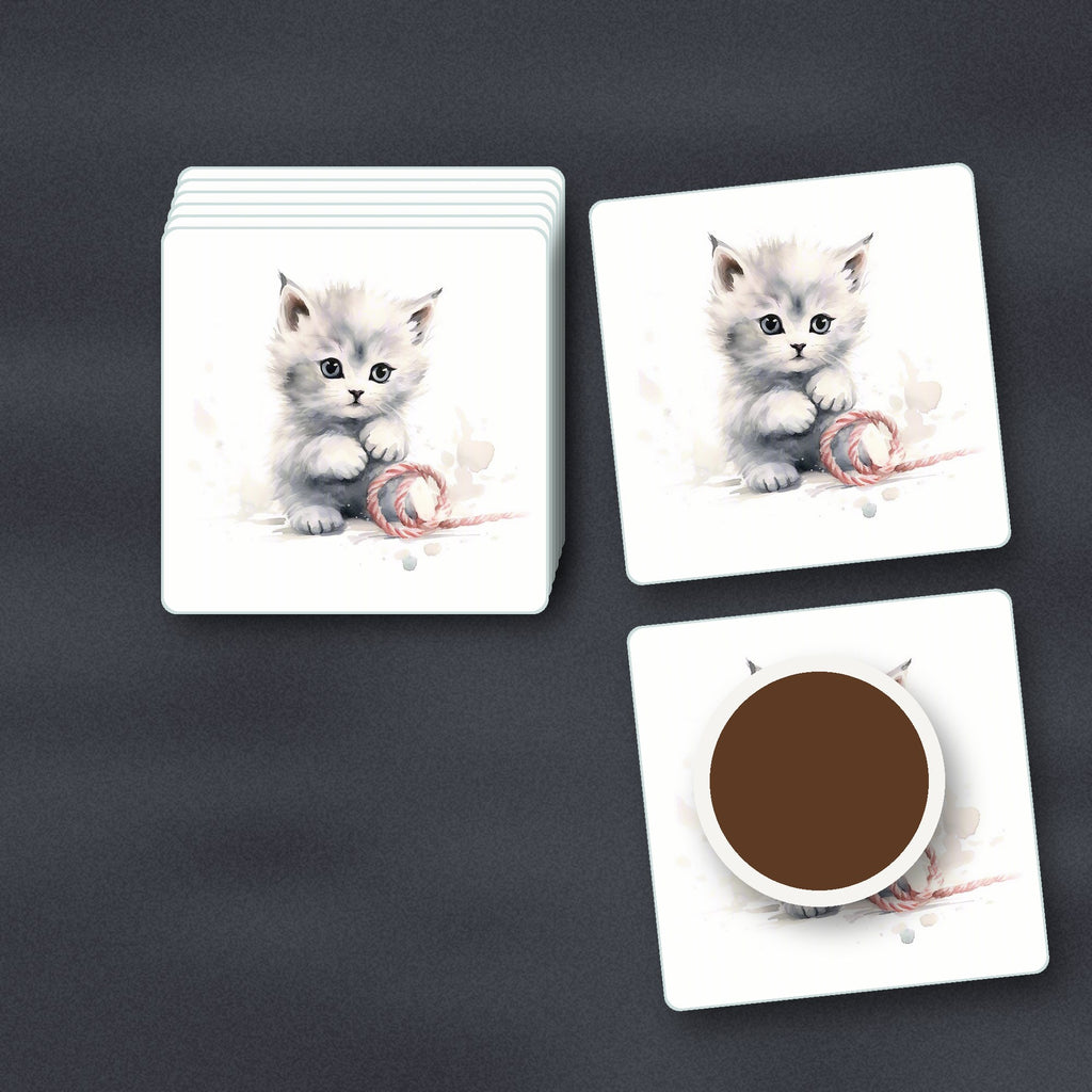 White Kitten with Yarn square glass coasters stacked on a slate kitchen worktop
