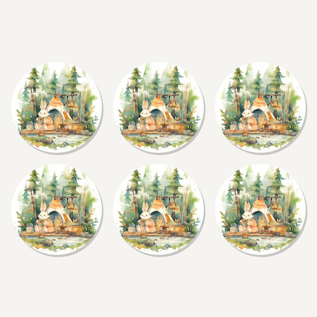 Flat lay of the rabbit campsite in the pines artwork on six round coasters