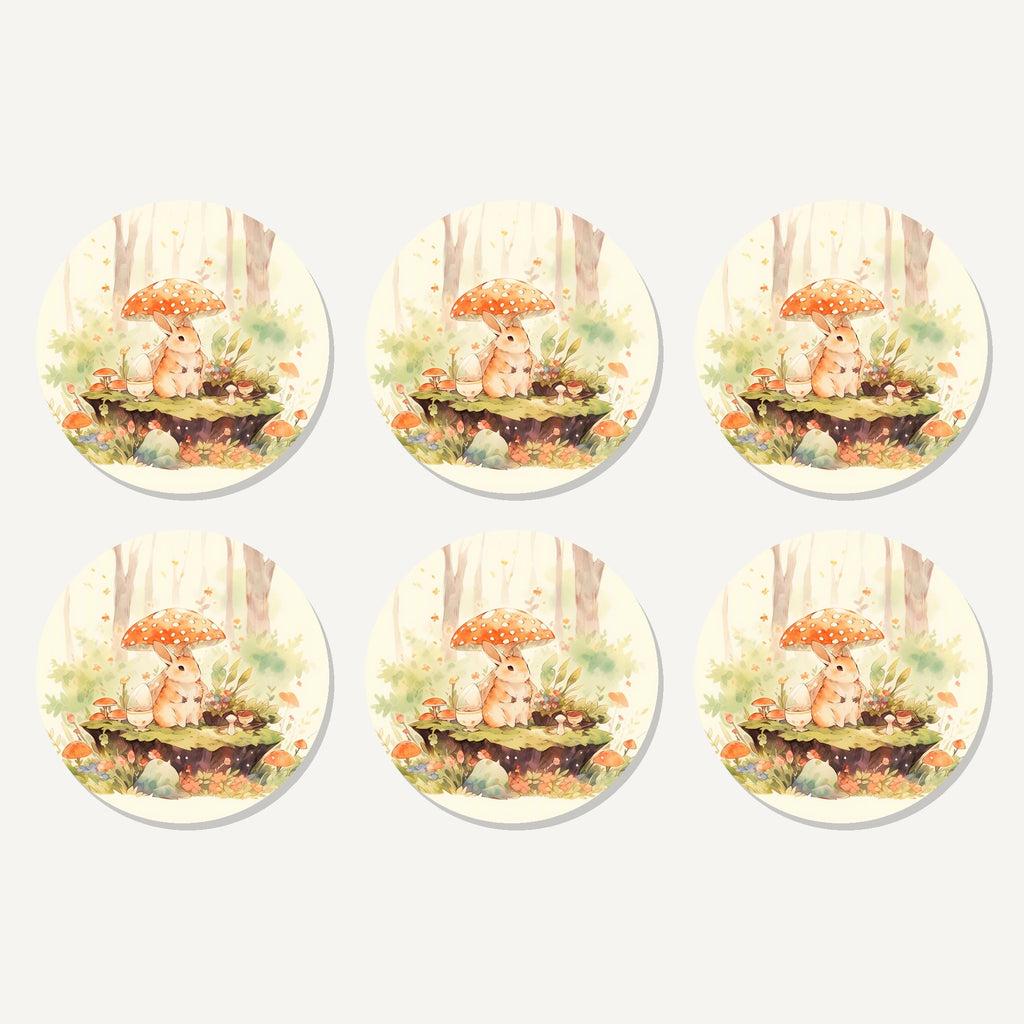 Flat lay of the rabbit under a toadstool artwork on six round coasters