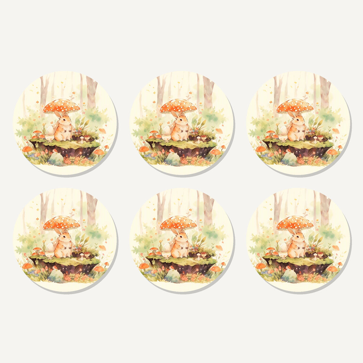 Flat lay of the rabbit under a toadstool artwork on six round coasters