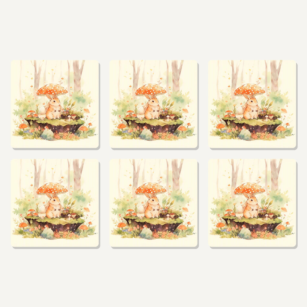 Flat lay of the rabbit under a toadstool artwork on six square coasters