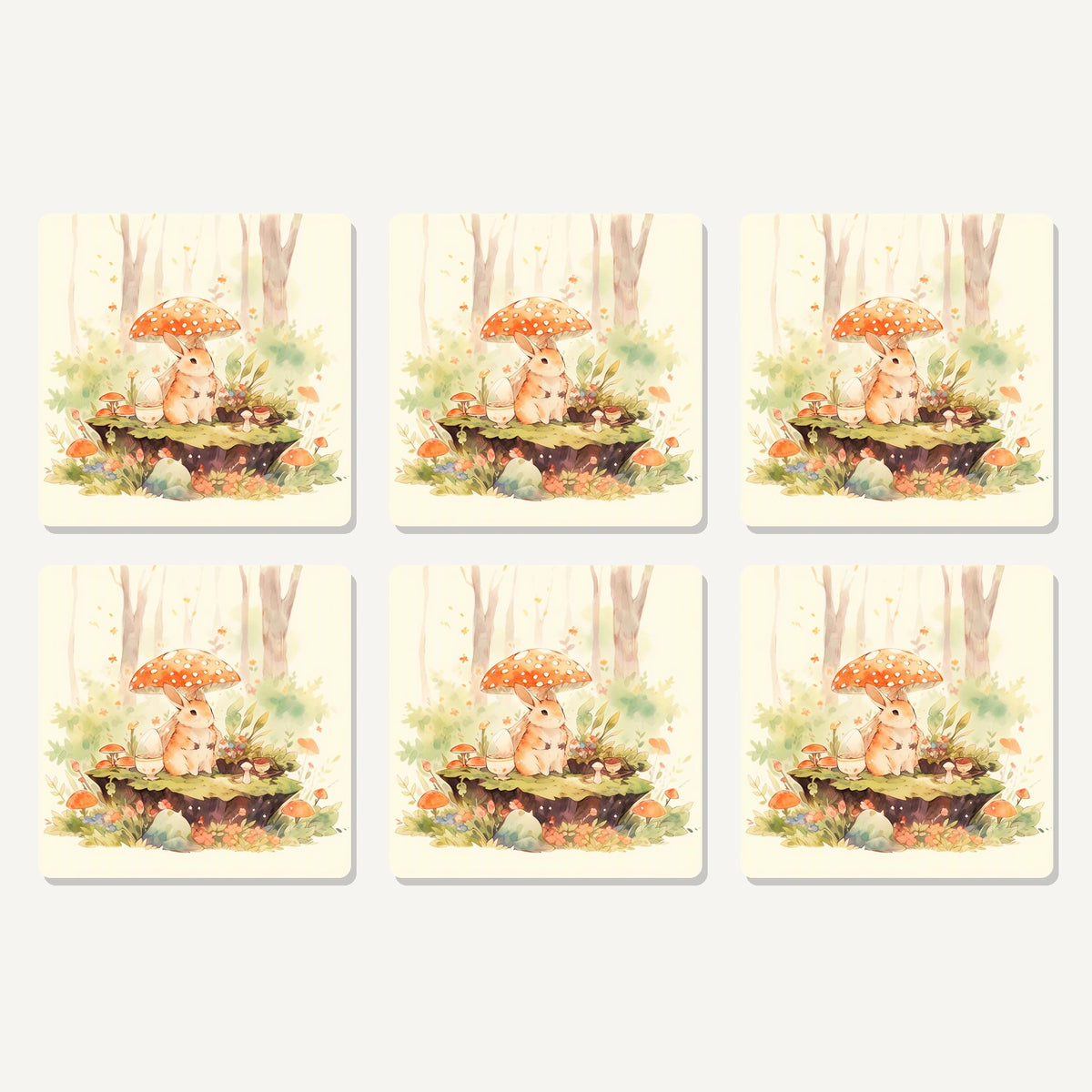 Flat lay of the rabbit under a toadstool artwork on six square coasters