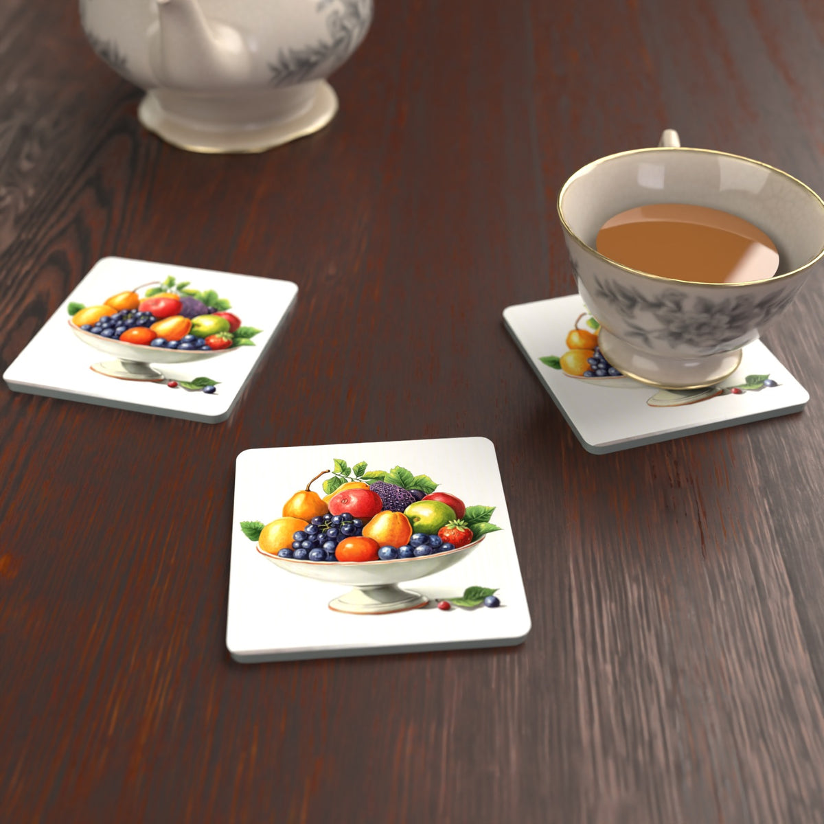 Fruit in a Footed Bowl Square Glass Coasters – Set of 6 – lifestyle mockup with a teacup