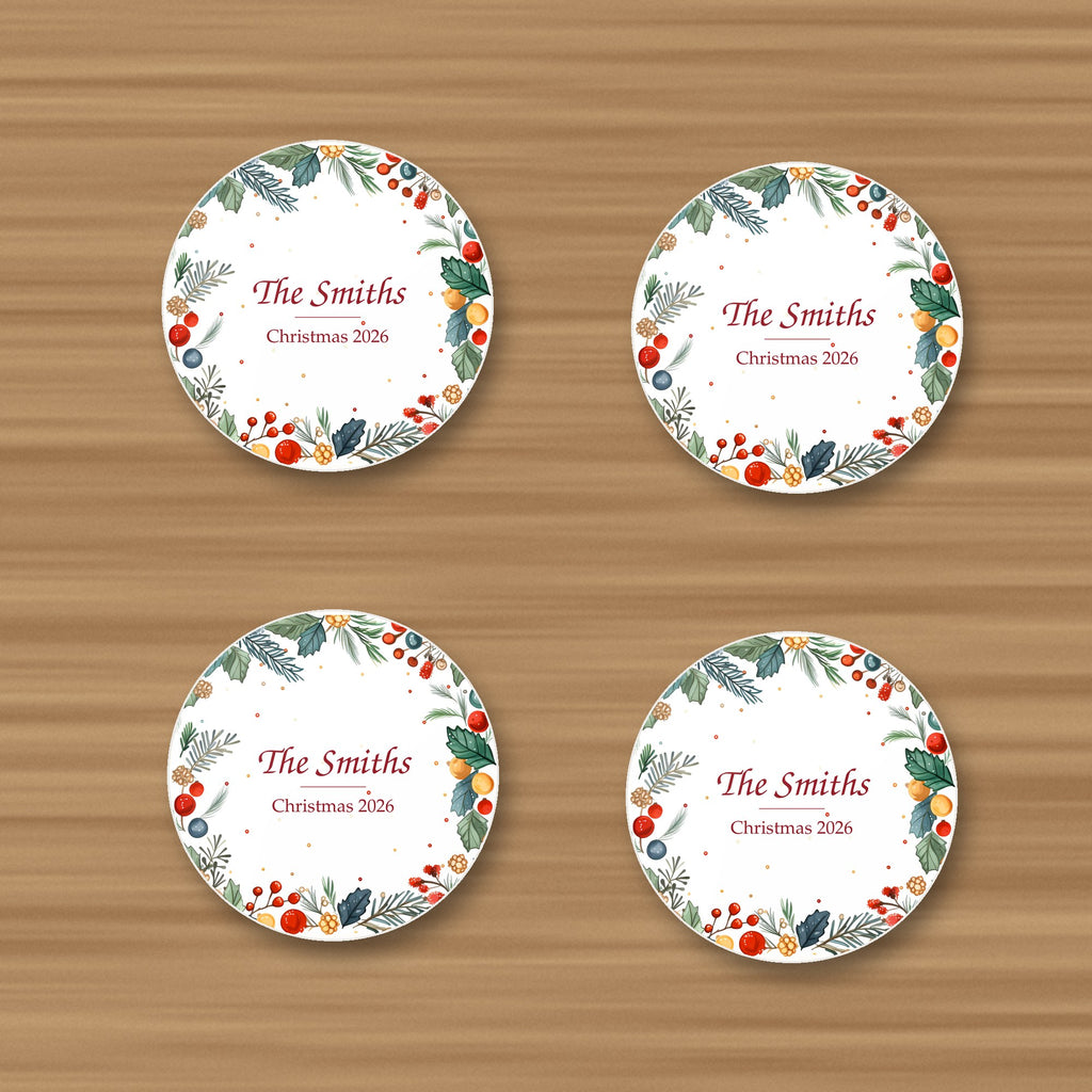 Set of 4 personalised holly and berry wreath coasters reading The Smiths, Christmas 2026, glossy, on an oak table