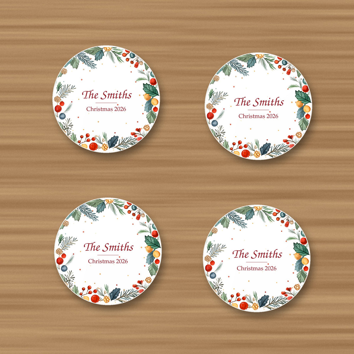 Set of 4 personalised holly and berry wreath coasters reading The Smiths, Christmas 2026, glossy, on an oak table