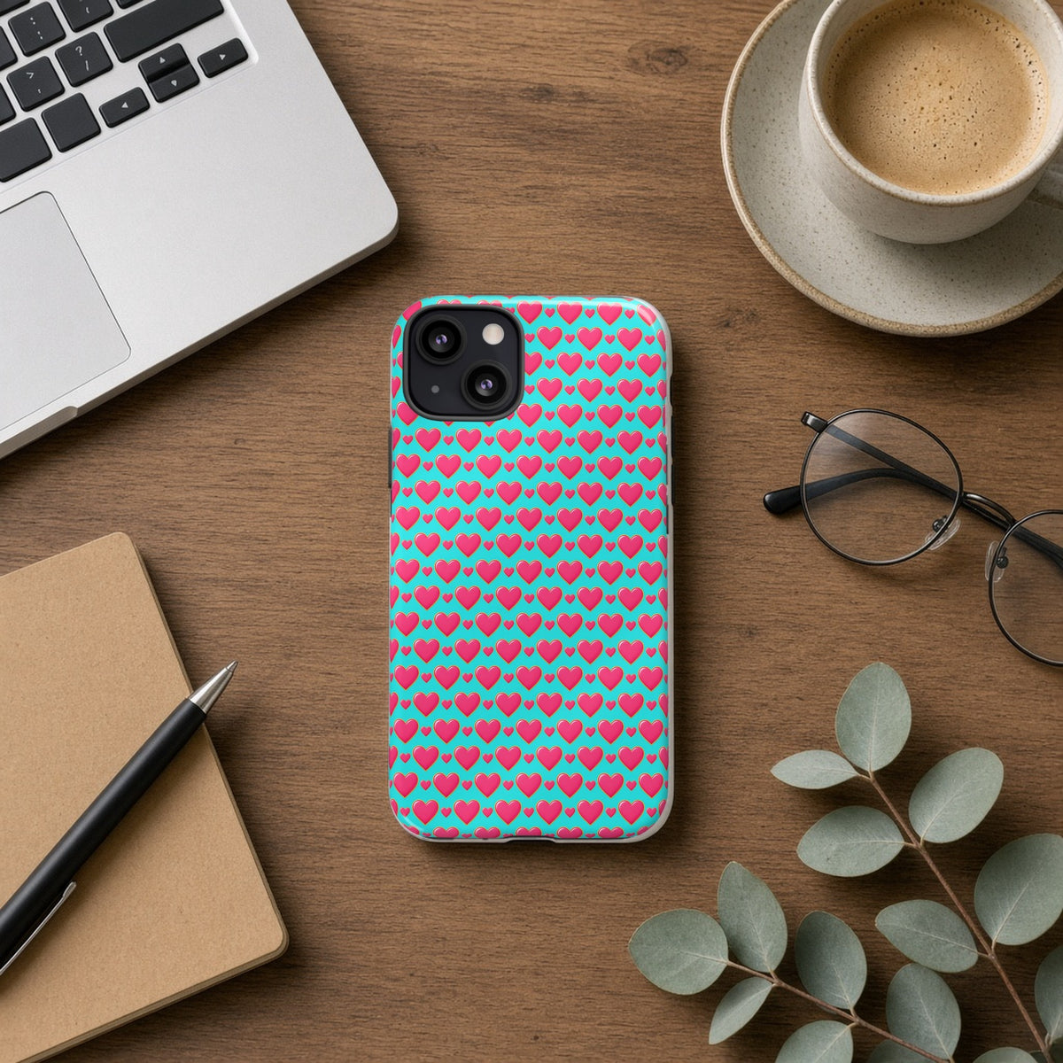Heart Bubble Grid tough phone case on a wooden desk beside a laptop, coffee and eucalyptus