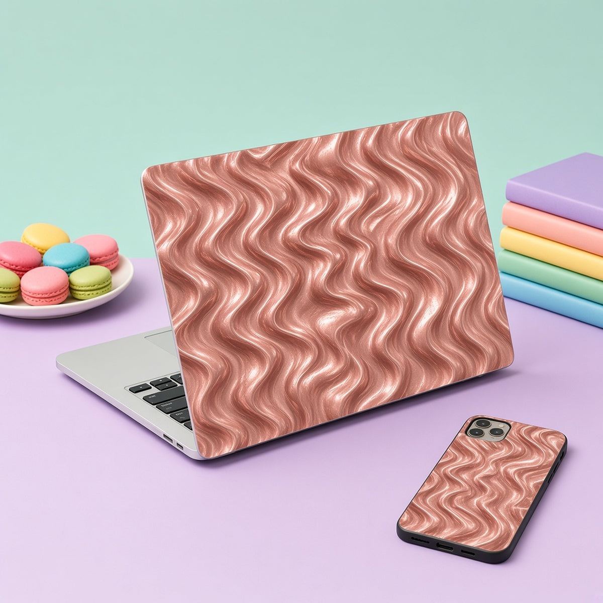 Laptop skin and phone case in rose-gold forged metal ripples on a lilac desk with macarons, made with prompt #864