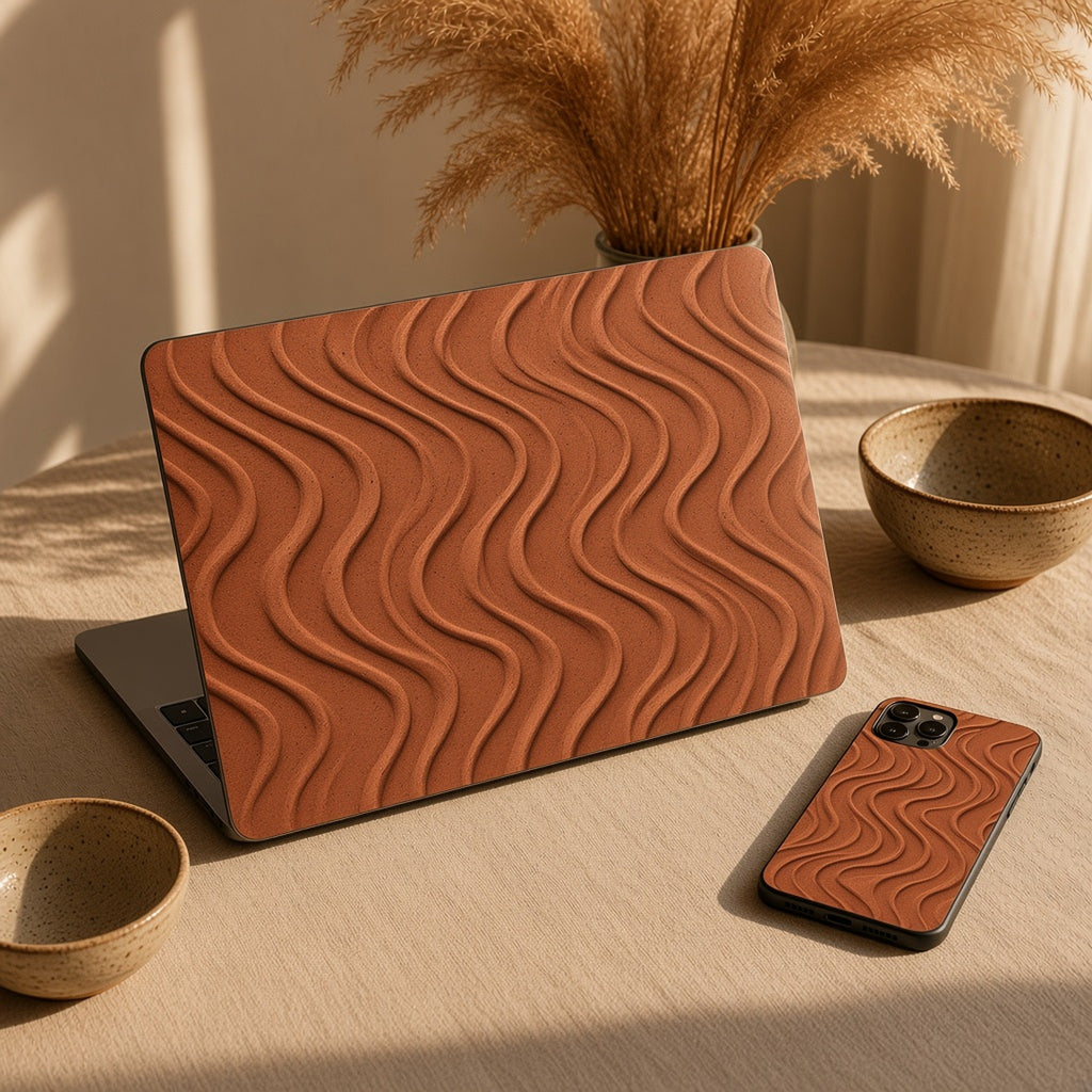 Laptop skin and phone case in terracotta flowing contour ribbons on a linen table with ceramics, made with prompt #323