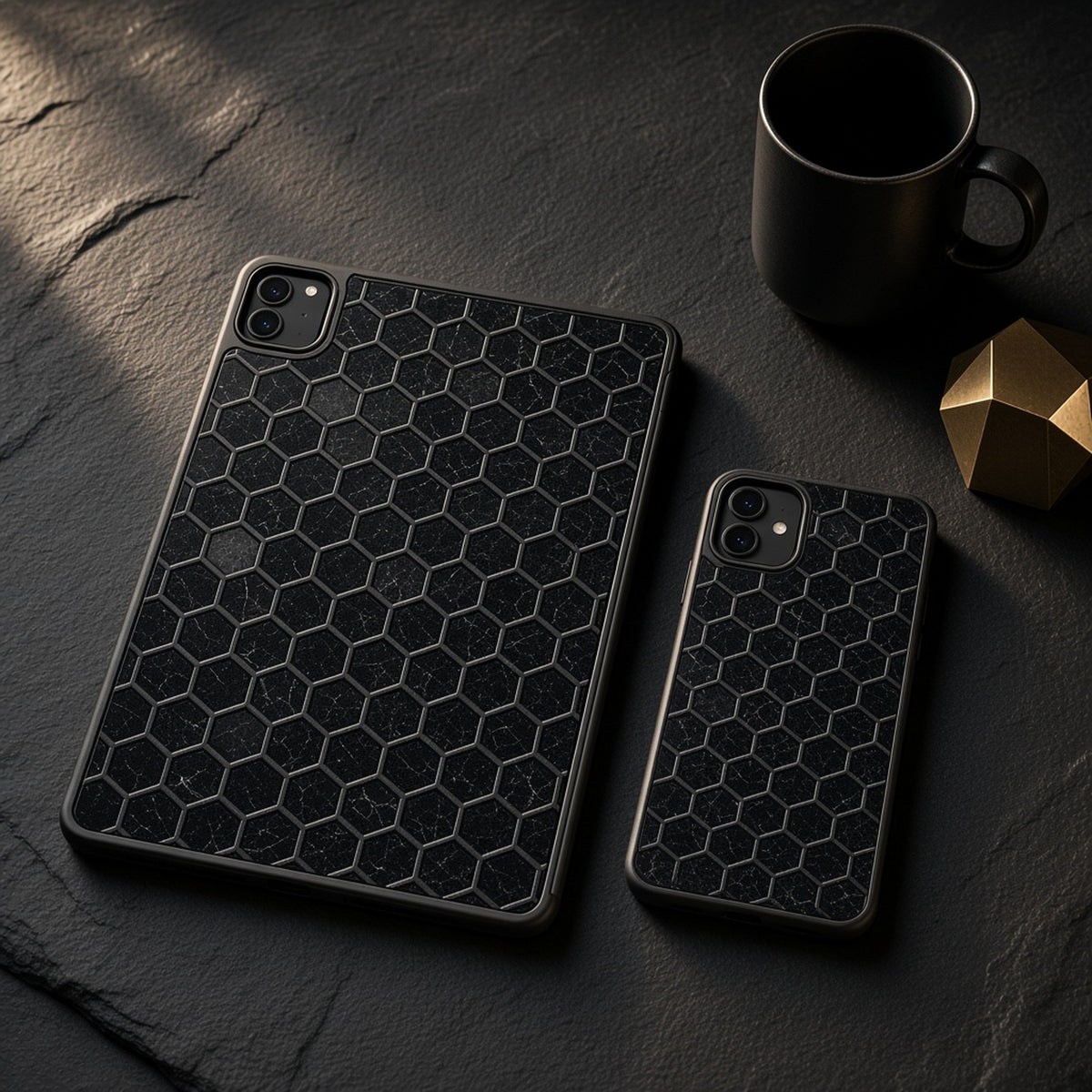 Tablet and phone cases in a black marble honeycomb lattice on a slate desk, made with prompt #97