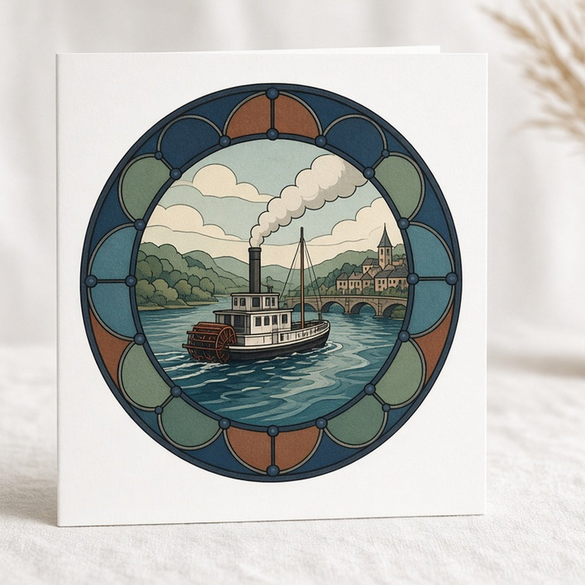 Rose-window river scene with a steam paddle boat, bridge and village printed flat on a greeting card, made with prompt #47