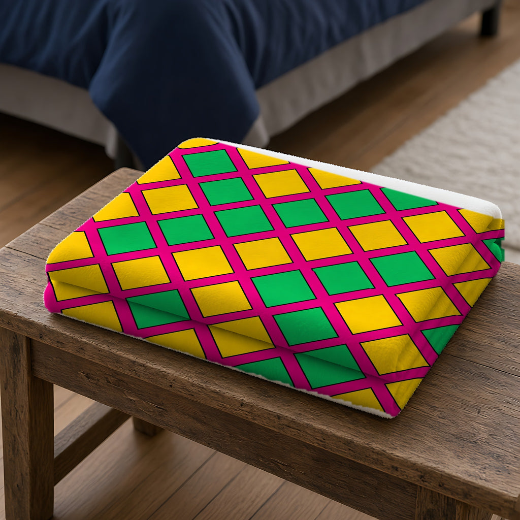 Harlequin Gold Grid Sherpa Fleece Blanket folded on a wooden bench