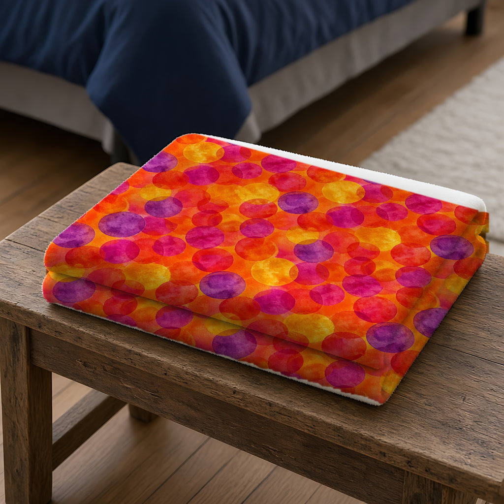 Glaze Circle Overlaps Sherpa Fleece Blanket folded on a wooden bench