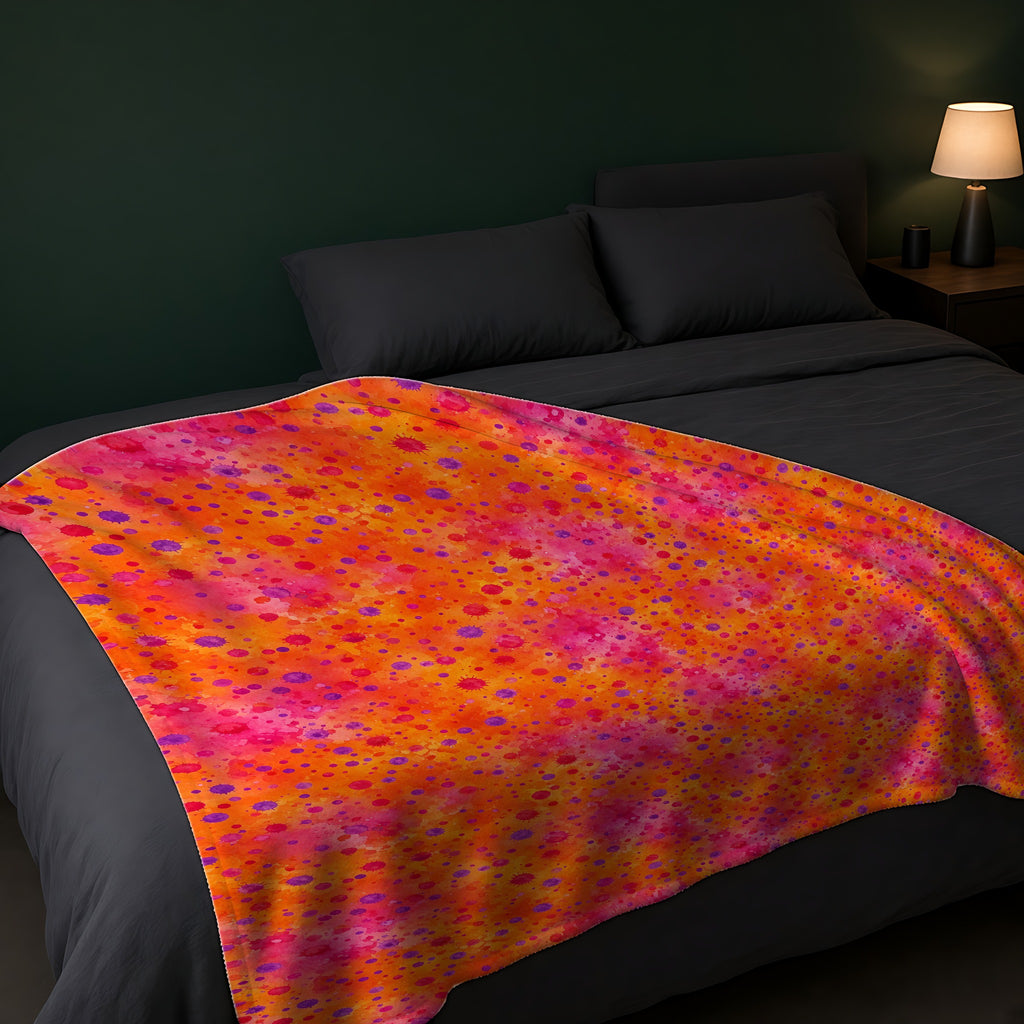 Pigment Dot Bleeds Sherpa Fleece Blanket across the foot of a dark bed