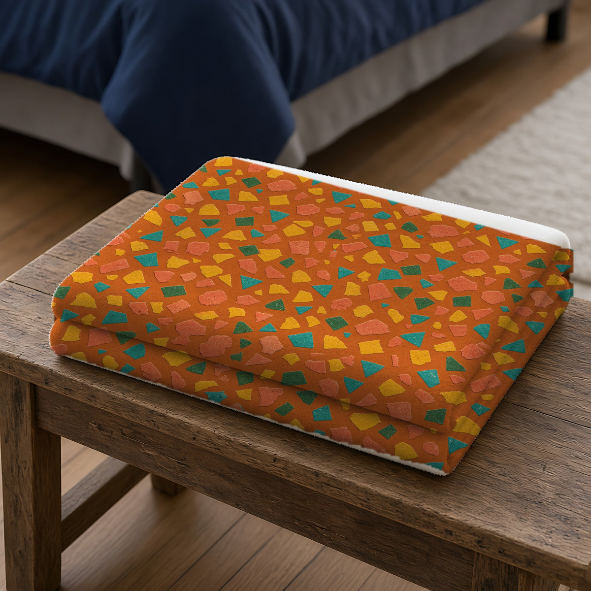 Angular Shard Scatter Sherpa Fleece Blanket folded on a wooden bench