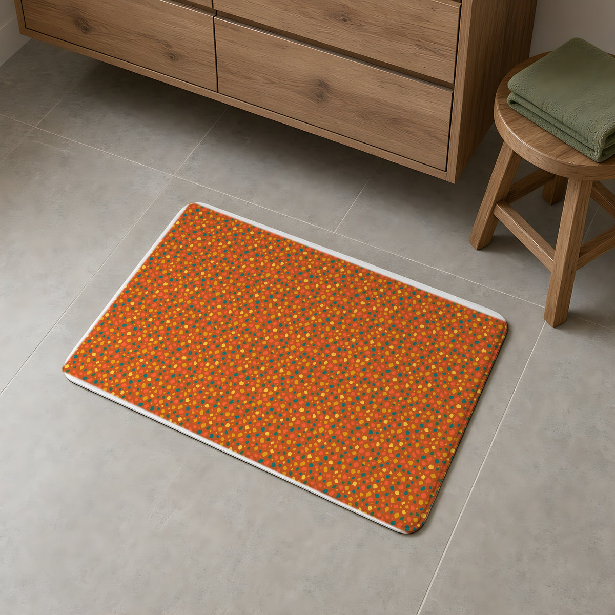 Confetti Aggregate Bath Mat on a grey tiled bathroom floor